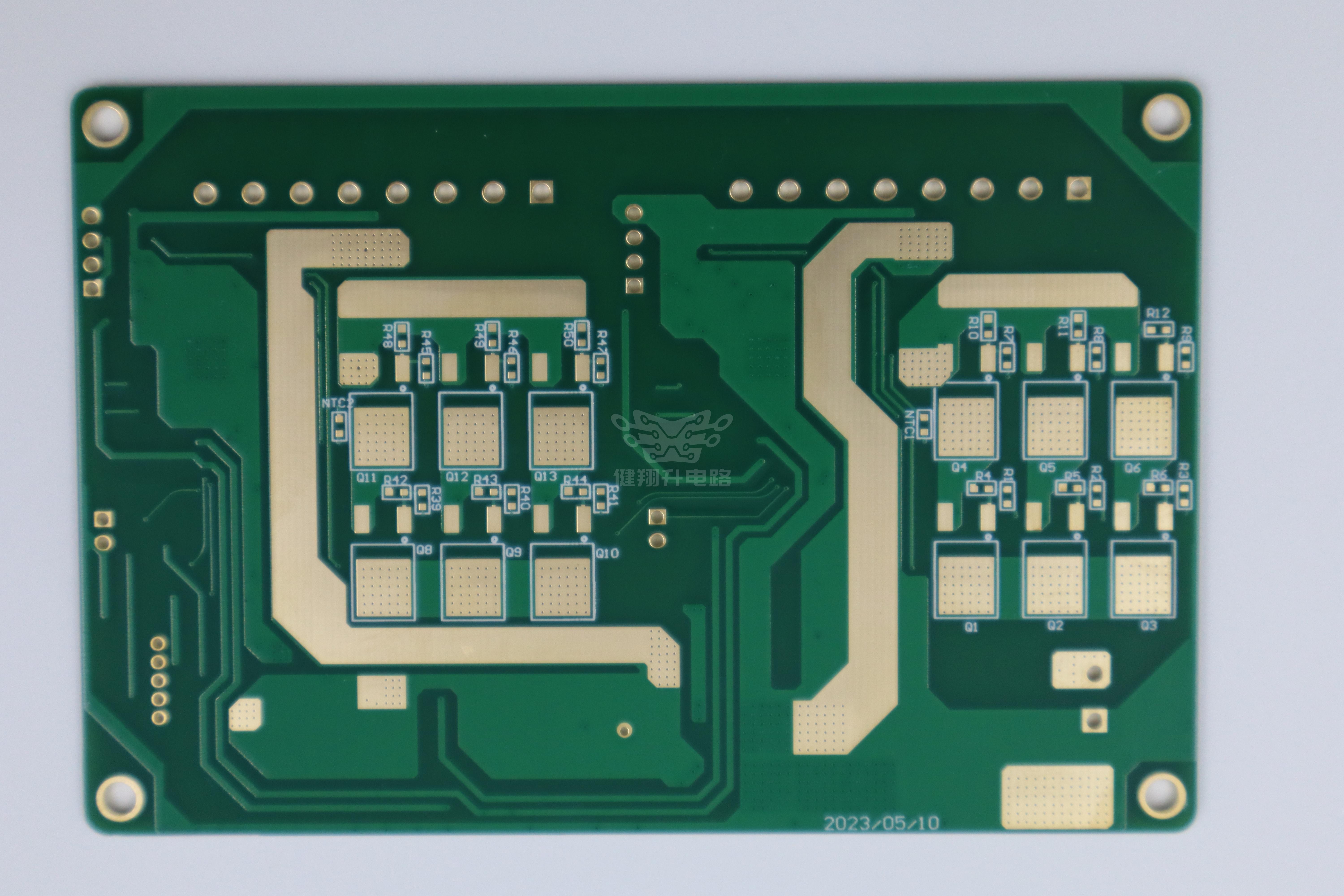 厚铜大电流PCB实物图：绿色阻焊板+粗电源走线+金色功率焊盘，展示成品铜厚与导体宽度